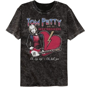 Op de afbeelding: Zwart T-shirt met een vervaagde, vintage-stijl afbeelding van Tom Petty and the Heartbreakers. De afbeelding bevat een portret van Tom Petty die gitaar speelt, een rood hart met een bliksem en de tekst "TOM PETTY AND THE HEARTBREAKERS". De tekst "Oh, my, my - Oh, hell, yes" is onder de afbeelding gedrukt.