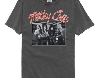 Puede incluir: Una camiseta negra con un aspecto descolorido que presenta una foto en blanco y negro de la banda Motley Crue. El nombre de la banda está escrito en rojo sobre la foto.