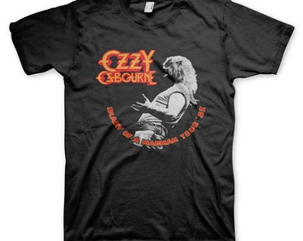 May include: Black t-shirt with a vintage-style graphic of Ozzy Osbourne from the "Diary of a Madman Tour '81" tour. The graphic features a black and white image of Ozzy performing on stage, with the tour name and date in red and orange text.