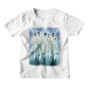 Peut inclure: T-shirt blanc avec un graphique d'un boys band, avec le mot "Millennium" en police bleue et blanche.