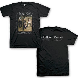 May include: Black t-shirt with a white graphic print of a band called "Leftöver Crack". The graphic includes a photo of the band members and the text "New York City's Most Evil Ska Punk Band". The back of the shirt has the band's name and the text "Shoot the Kids at School".
