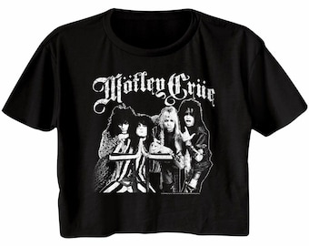 Può includere: T-shirt nera corta con un'immagine in bianco e nero della band Mötley Crüe. Il nome della band è stampato in un font stilizzato sopra l'immagine. La t-shirt ha maniche corte e girocollo.