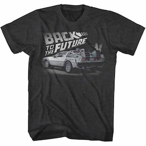 May include: A dark gray t-shirt with a white graphic of the DeLorean time machine from the movie "Back to the Future". The text "Back to the Future" is printed in white above the car.