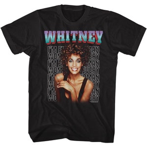 Może przedstawiać: Czarny T-shirt z fotografią Whitney Houston i tekstem "WHITNEY" w kolorowej czcionce. Tekst "I'M EVERY WOMAN" jest powtarzany w kolumnie po prawej stronie koszulki.