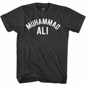 Puede incluir: Una camiseta gris oscuro jaspeada con un gráfico blanco de estilo vintage que dice "Muhammad Ali" en arco.