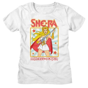 May include: White t-shirt with a retro-style illustration of She-Ra, Princess of Power. She-Ra is holding a sword and wearing a red cape and a white skirt. The text "She-Ra" and "Princess of Power" are in red.