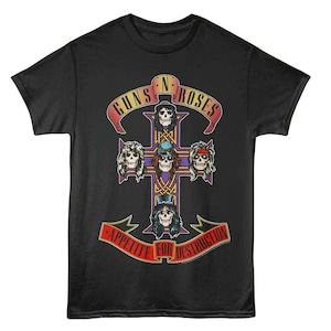 Puede incluir: Camiseta negra con un diseño gráfico que presenta el texto "GUNS N' ROSES" y "APPETITE FOR DESTRUCTION". El diseño incluye una cruz con ilustraciones de calaveras. La camiseta está hecha de un material suave.