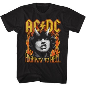 Pode incluir: Camiseta preta com um gráfico amarelo e laranja de um logotipo de banda, "AC/DC", e as palavras "Highway to Hell". O gráfico apresenta um diabo com chifres e chamas.