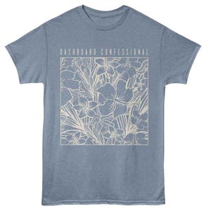 May include: A pale blue t-shirt with a floral pattern enclosed in a rectangle. The design features flowers and leaves in a light beige hue. The text "DASHBOARD CONFESSIONAL" is printed above the floral design.
