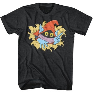 May include: A dark grey t-shirt with a cartoon character wearing a red hat and a blue mask peeking out from behind a yellow flower. The character has two large black eyes and is making a peace sign with one hand.
