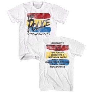 May include: White t-shirt with a colorful graphic of the band The Police and the album title "Synchronicity". The back of the shirt lists the songs from the album: "Synchronicity I", "Walking in Your Footsteps", "O My God", "Mother", "Miss Gradenko", "Synchronicity II", "Every Breath You Take", "King of Pain", "Wrapped Around Your Finger", "Tea in the Sahara", and "Murder by Numbers".