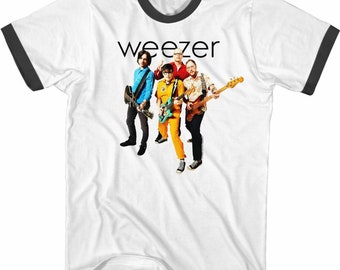 Puede incluir: Camiseta blanca con cuello de canalé negro y un gráfico de la banda Weezer. Los miembros de la banda llevan ropa colorida y sostienen guitarras.