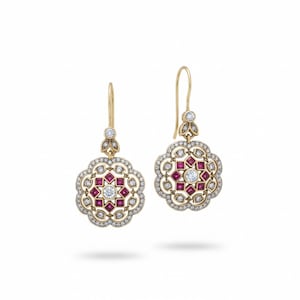 Può includere: Un paio di orecchini pendenti color oro. Ogni orecchino presenta un design floreale con una gemma bianca centrale, circondata da gemme quadrate rosse e gemme bianche più piccole. Gli orecchini hanno una chiusura a gancio e un piccolo gruppo di gemme.