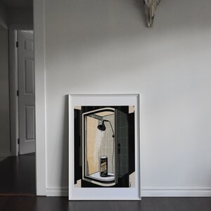 Puede incluir: Una impresi&oacute;n enmarcada de una ilustraci&oacute;n en blanco y negro de una ducha con una lata de comida en su interior. La ducha est&aacute; en un ba&ntilde;o con azulejos. La impresi&oacute;n est&aacute; en un marco blanco.