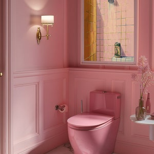 May include: A pink bathroom with a matching toilet, walls, and marble flooring. A framed painting depicts a shower scene with a beer can. A gold sconce with a lampshade is mounted on the wall. A small table holds a vase of flowers.