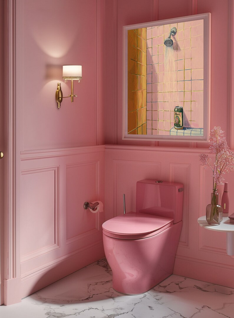 May include: A pink bathroom with a matching toilet, walls, and marble flooring. A framed painting depicts a shower scene with a beer can. A gold sconce with a lampshade is mounted on the wall. A small table holds a vase of flowers.