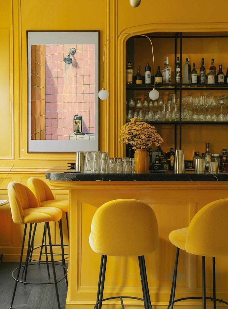 May include: A vibrant yellow bar with matching stools and a black countertop. A framed artwork depicts a shower scene with a beer can. The bar is stocked with glassware and bottles, and a vase of yellow flowers adds a pop of color.