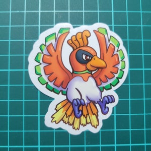 May include: A sticker featuring a cartoon illustration of a red, orange, green, and yellow bird with a white body and a green and white head. The bird is flying with its wings spread out.