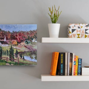 May include: A painting of a white church with a steeple in a rural setting. The church is surrounded by trees with red, orange, and yellow leaves. The painting is done in a loose, impressionistic style.