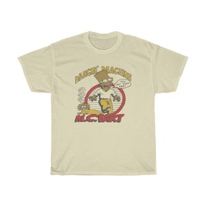 May include: A yellow t-shirt featuring a cartoon image of Bart Simpson from The Simpsons, dancing. The text "Dancin' Machine" is above the image and "M.C. Bart" is below the image. The text "You can't touch this!" is in a speech bubble above Bart's head.