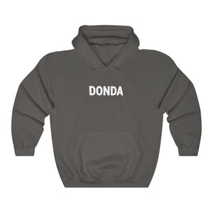 May include: A dark gray hooded sweatshirt with the word "DONDA" printed in white on the front.