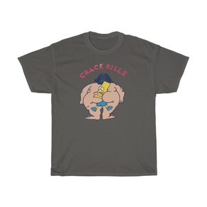 May include: A dark grey t-shirt featuring a cartoon image of a yellow character with blue shorts and black hair. The character is being hugged by a larger, nude character with black hair. The text "CRACK KILLS" is printed in pink above the characters.