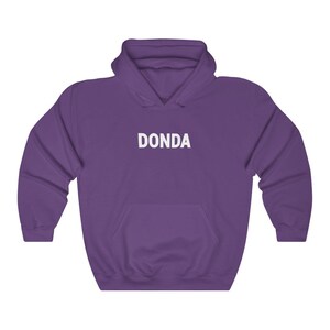 May include: Purple hooded sweatshirt with the word "DONDA" printed in white on the front.