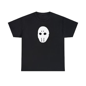 May include: Black t-shirt featuring a white hockey mask graphic. The mask has two eye holes and several mouth and cheek holes. The t-shirt is made of a soft material.