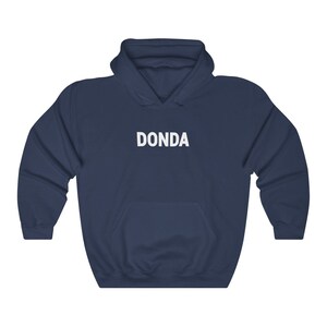 May include: A navy blue hoodie with a white "DONDA" logo printed on the front.