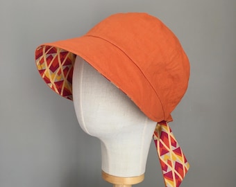 PETRONILLE orange linen capeline with reversible geometric pattern