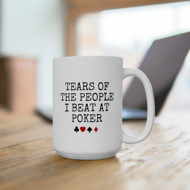 Puede incluir: Taza de caf&eacute; de cer&aacute;mica blanca con texto negro que dice "Tears of the people I beat at poker" y cuatro s&iacute;mbolos de palo de cartas rojas y negras.