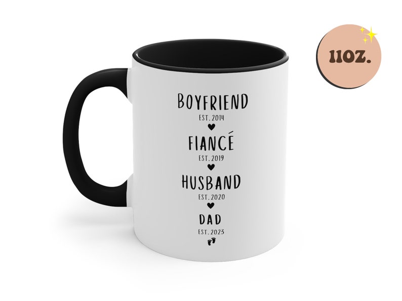 K&ouml;nnte beinhalten: Eine wei&szlig;e Keramiktasse mit schwarzem Rand und Henkel. Die Tasse hat einen schwarzen Text mit der Aufschrift "Boyfriend Est. 2014", "Fianc&eacute; Est. 2019", "Husband Est. 2020" und "Dad Est. 2025".
