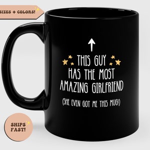 May include: Black coffee mug with white text that reads "↑ This guy has the most amazing girlfriend (She even got me this mug!)" with gold stars.