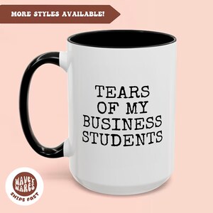 May include: White ceramic coffee mug with a black handle and black rim. The mug has the text "TEARS OF MY BUSINESS STUDENTS" printed in black.