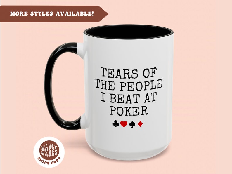 Puede incluir: Taza de caf&eacute; de cer&aacute;mica blanca con asa y borde negros. La taza tiene texto negro que dice "Tears of the people I beat at poker" con cuatro s&iacute;mbolos de cartas de juego negras debajo del texto: un tr&eacute;bol, un coraz&oacute;n, una pica y un diamante.