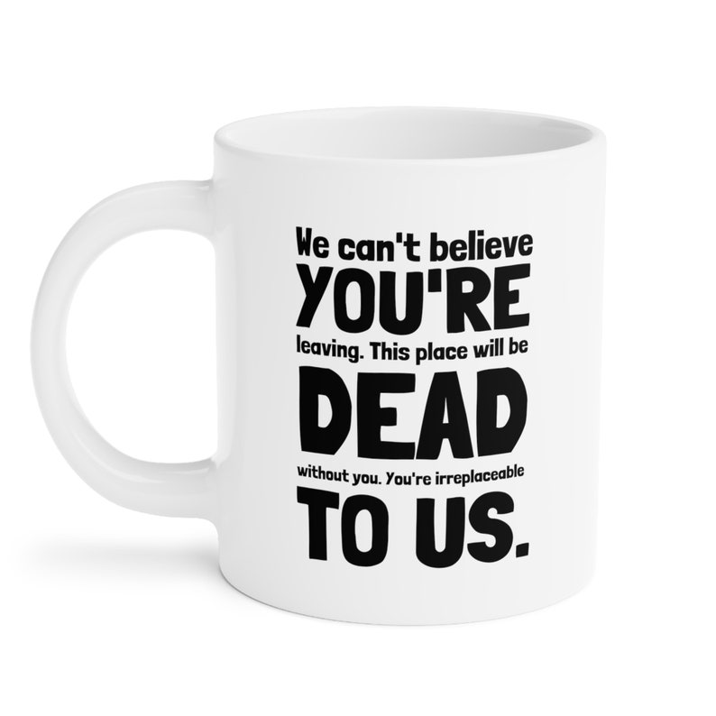 May include: White ceramic coffee mug with black text that reads "We can't believe YOU'RE leaving. This place will be DEAD without you. You're irreplaceable TO US."