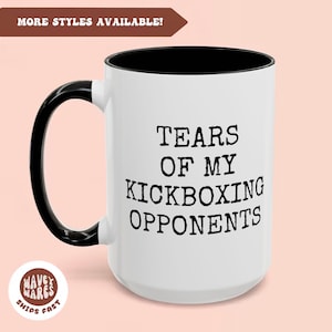 May include: White ceramic coffee mug with a black rim and handle. The mug has black text that reads "Tears of my Kickboxing Opponents".