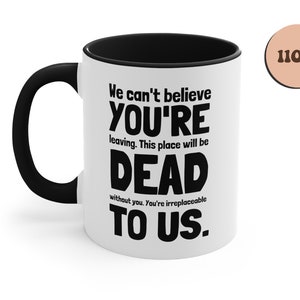 May include: White ceramic mug with a black handle and black rim. The mug has a funny saying printed on it in black text: "We can't believe you're leaving. This place will be dead without you. You're irreplaceable to us." The mug is 11 oz.