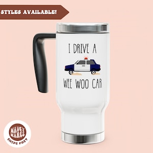 May include: White travel mug with a black handle and silver accents. The mug features the text "I drive a wee woo car" with an illustration of a police car. The mug has a lid and is designed for hot or cold beverages.