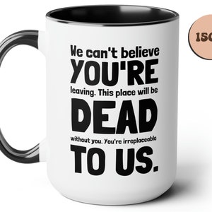 May include: White ceramic mug with a black handle and black rim. The mug has black text that reads "We can't believe YOU'RE leaving. This place will be DEAD without you. You're irreplaceable TO US." The mug is 15 ounces.