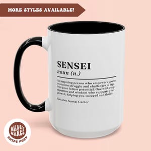 May include: White ceramic mug with a black handle and rim. The mug features a black and white graphic with the word "Sensei" and a definition of the word. The definition reads: "An inspiring person who empowers you to overcome struggle and challenges to tap into your fullest potential. One with deep expertise and wisdom who supports your growth, helping you succeed and thrive. See also: Sensei Carter."