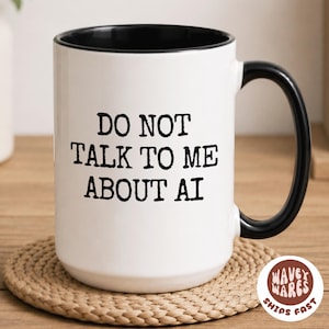 May include: White ceramic mug with a black interior and handle. The mug features the text "DO NOT TALK TO ME ABOUT AI" in black, bold letters. The mug sits on a woven coaster. A logo with the text "Wavey Wares" is visible.