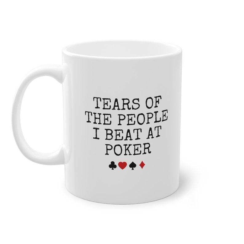 Puede incluir: Taza de caf&eacute; de cer&aacute;mica blanca con texto negro que dice "Tears of the people I beat at poker" con cuatro s&iacute;mbolos de palo de cartas negras y rojas debajo del texto.