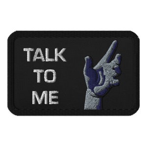 May include: Black embroidered patch with white text that reads "TALK TO ME" and a silver and blue hand pointing to the right.