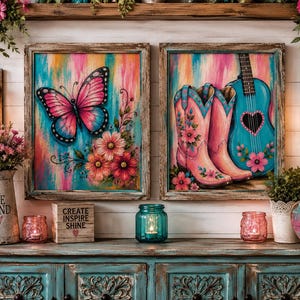 Op de afbeelding: Twee ingelijste wandkunstwerken met een roze vlinder met bloemen en een paar roze cowboylaarzen met een turquoise gitaar. De scène bevat een witte kan met de tekst BE KIND, een houten blok met CREATE INSPIRE SHINE en glazen potten.