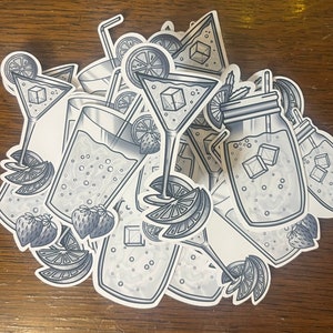 May include: A set of black and white stickers featuring various summer drinks, including a mason jar, a martini glass, and a glass with a straw. The stickers feature lemons, strawberries, and ice cubes.