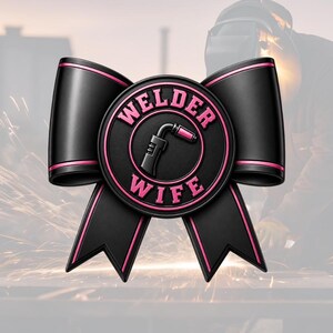 May include: A black bow with pink trim and a circular emblem. The emblem features the words "WELDER WIFE" in pink, surrounding a graphic of a welding torch. The background shows a welder at work.