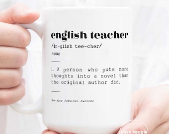 May include: White ceramic mug with black text that reads "english teacher /in-glish tee-cher/ noun 1. A person who puts more thoughts into a novel than the original author did. See also: Fabulous Awesome" and a small black and white logo that reads "Love People As Yourself."