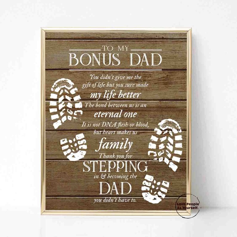 Puede incluir: Un fondo de madera con un mensaje en blanco que dice "To My Bonus Dad." El mensaje est&aacute; rodeado de huellas blancas. El texto dice: "You didn't give me the gift of life but you sure made my life better. The bond between us is an eternal one. It is not DNA flesh or blood, but heart makes us family. Thank you for stepping in & becoming the Dad you didn't have to."