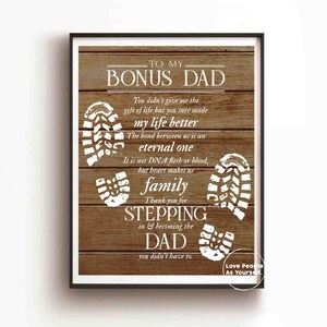 Puede incluir: Un fondo de madera con texto blanco que dice "To My Bonus Dad". El texto contin&uacute;a con un mensaje sobre el v&iacute;nculo entre un padrastro y un hijo. El fondo est&aacute; decorado con huellas blancas.